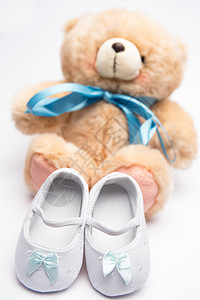 带蓝丝带和白靴子的泰迪熊背景图片