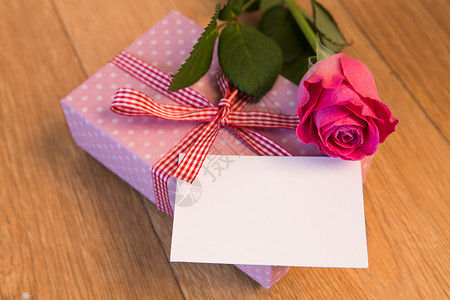 用空白卡和粉红玫瑰包裹的粉红色礼物背景图片