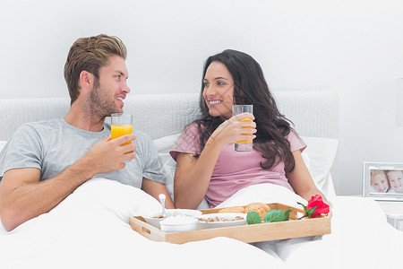美朝关系漂亮的一对在床上吃早餐的美夫妻背景