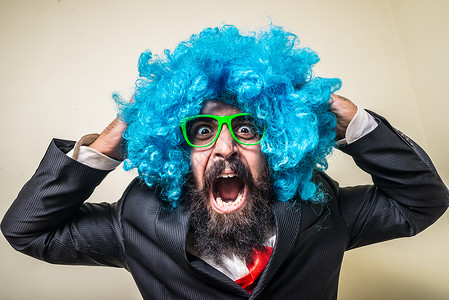 长着蓝假发的胡须男子创造力眼镜男人绿色派对震惊音乐幸福狂欢夹克背景图片