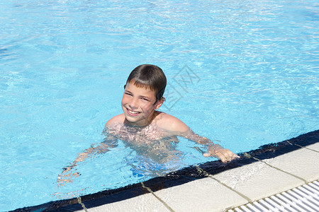 游泳池元素在游泳池上的活动 可爱男孩游泳和在水中玩男性手镯护目镜假期青年晴天运动水池乐趣微笑背景