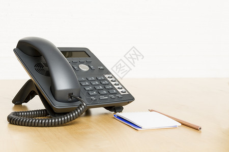 电话在办公桌上 木制桌上有注纸热线电话键盘选择性木材焦点铅笔中心网络呼叫经济背景