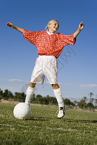 一名在野外踢足球的年轻女运动员全年高清图片