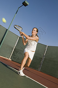 体育项目打网球一名女性网球运动员在网球场打反手的全年打网球员球赛闲暇休闲活动行动娱乐用品消遣专注反手背景
