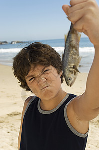 单个鱼素材小男孩在沙滩上钓鱼活动娱乐摄影男孩们男生童年海滩海岸眼神男性背景