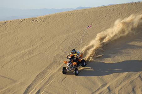 电视节目预告人间怖在沙漠沙丘上骑ATV的年轻人背景