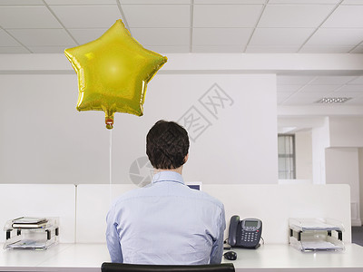 电话形状素材在办公室的气球旁边 一个人单独工作的人的近视背景