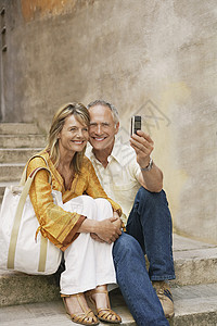 幸福的情侣在台阶上 用手机拍摄自己高清图片