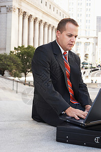 前滩晶耀商务广场使用户外手提笔记本电脑持公用公文包的自信商务人士背景