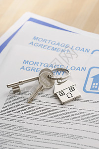 新住宅和抵押贷款文件放在桌面上的钥匙背景图片