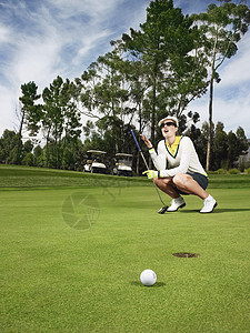 圆滚滚球员一充满失望的女高尔夫球员在投绿色背景