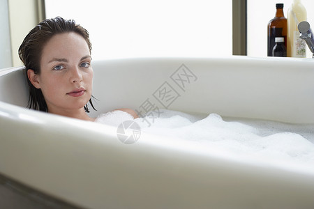 年轻女性在泡泡浴中放松的肖像高清图片