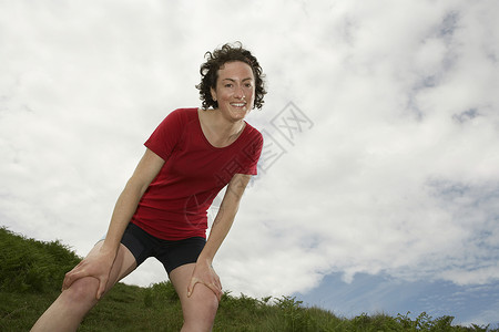 一名女性徒行者在风云中站立的低角度视角背景图片