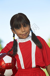 一个小女球员拿着足球球的肖像高清图片