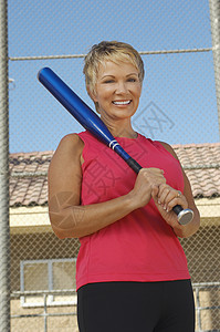 一位拿着棒球棒的高加索女人的快乐肖像背景