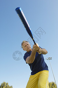 玩棒球棍对着蓝天挥棒的高级活跃男子高清图片