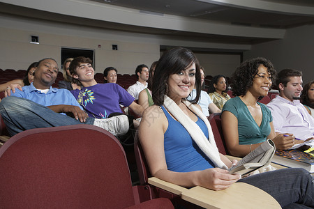 坐在课堂肖像中的女学生学生班级会场大学生讲座女士黑发教科书沙漠棕榈背景图片