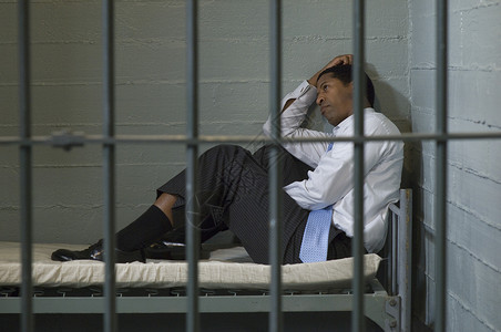 关押在牢房中床上的成年男子情绪刑事焦虑痛苦惩罚白领黑人商务法制领带背景