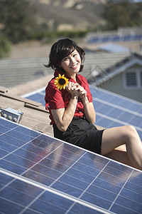 坐在屋顶上一位女士坐在太阳般的屋顶上 拿着向日葵背景