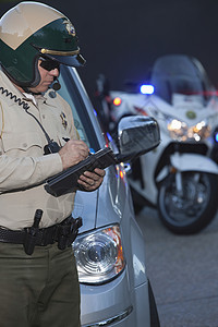 巡警站着 准备出车票太阳镜警察法律成人大灯摩托车长度绿色执法秩序图片