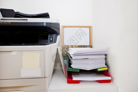 特写实际生活中办公室的打印机和书面文件工作高清图片