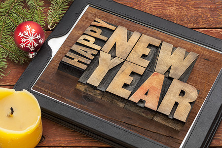 数字平板上的新年快乐蜡烛云杉商业新年木头问候语触摸屏电脑凸版季节背景图片