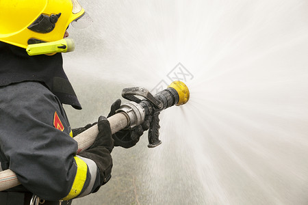 消防员培训情况喷涂救援危险消防头盔服务水带烧伤背景图片