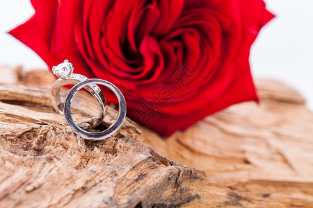 红色钻石素材木背景和红玫瑰上美丽的环子首饰玫瑰钻石假期情感戒指婚礼婚姻情人订婚背景