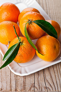汉语普通话盘子里有叶子的橘子桌子宏观水果果汁团体橙子饮食片段木头季节背景