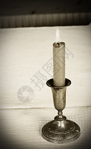 蜡烛黑与白古董火焰白色金属桌子桌布烛台织物棕褐色背景图片