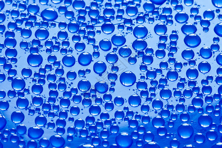 水滴反射宏观玻璃环境蓝色雨滴背景图片