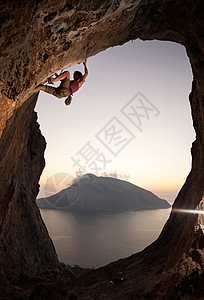 希腊卡利姆诺斯日落时女性攀岩者高清图片