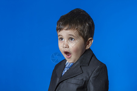 头儿 蓝色背景的可爱小男孩肖像男性电话办公室白色衣服领带儿子商务青年童年背景