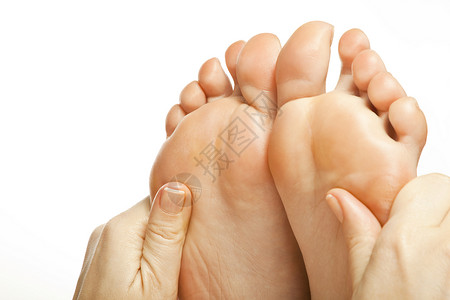女性腿脚按摩康复温泉足疗治疗玫瑰花瓣白色背景图片
