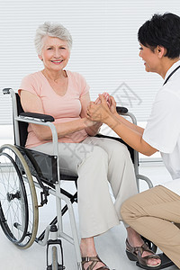 坐轮椅的病人医生与一名坐轮椅的高级病人交谈药品功能保健骨科女性人员讨论身体职业成人背景