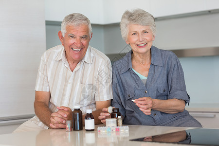 快乐的老年夫妇 组织他们的药物背景图片