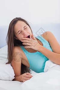 坐在床上的疲劳妇女打哈哈哈哈高清图片