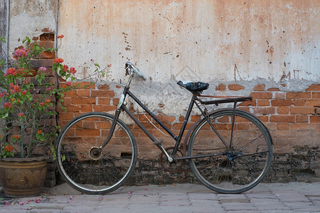 一辆旧自行车和一堵破墙背景图片
