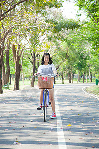 年轻骑自行车的女人喜悦女士活动花园幸福孩子运动女性成人乐趣背景图片