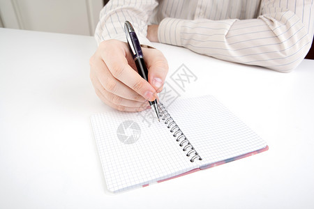 列出男人正在准备写作日记桌子手指白色笔记本商业作品日历工作背景