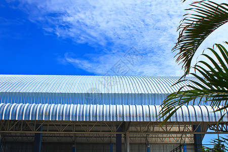 蓝色天空的屋顶铝厂 金属面板波纹车库镀锌涟漪盘子床单工厂平行线经济瓦楞背景