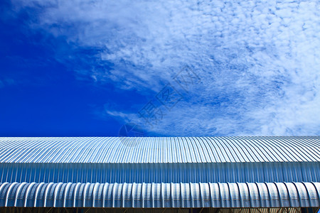 蓝色天空的屋顶铝厂 金属面板瓦楞平行线车库波纹商业建造工厂材料控制板涟漪背景
