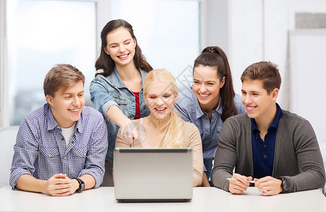 在学校看笔记本电脑的学生笑着青少年朋友们乐趣推介会演讲学习男人团队微笑技术背景图片