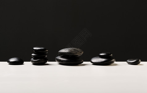 热按摩石的紧闭文化按摩桌子冥想黑色治疗福利毛巾白色卵石背景图片