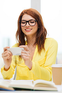 在学校有智能手机 微笑着的女学生游戏图书办公室大学学生技术青少年学习课堂女士背景图片