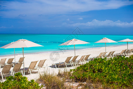 白色的伞奇特热带白色沙沙滩上的海滩椅海洋海景椅子天空旅游海岸线支撑旅行太阳奢华背景