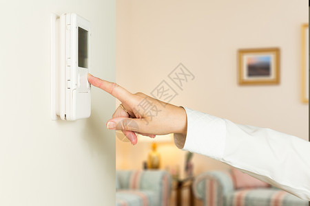 白种女人按现代自动调温器手臂活力手指技术控制消费者空调温度客厅冷却背景