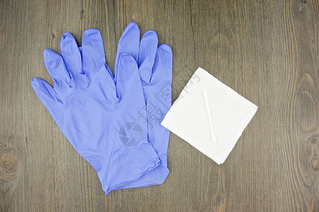 一双棉手套紫色乳胶手套和组织纸上的棉芽背景
