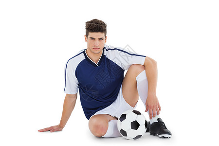 足球运动员与球一起坐在地上男性活动运动杯子团队世界齿轮闲暇专注球衣背景图片