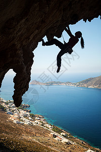 月光下登山者女孩在悬崖上攀岩的年轻女性月光活动绳索岩石运动登山者女士洞穴风景日落高度背景